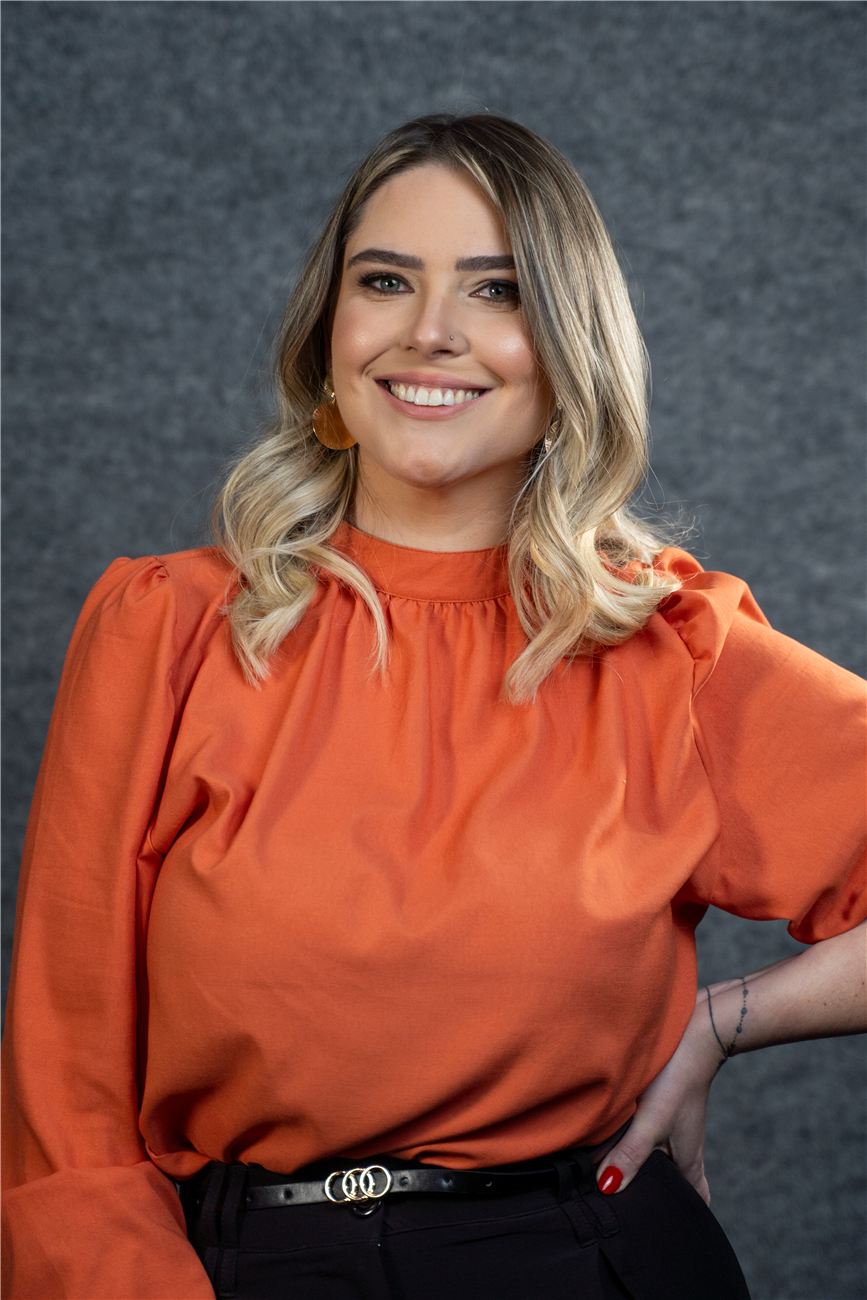 Raphaela Spellmeier sorrindo, de blusa laranja