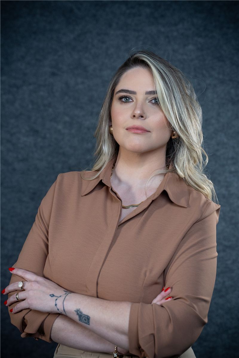 Raphaela Spellmeier de braços cruzados, de camisa marrom
