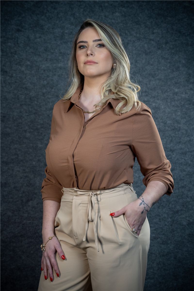 Raphaela Spellmeier em pé, de camisa marrom