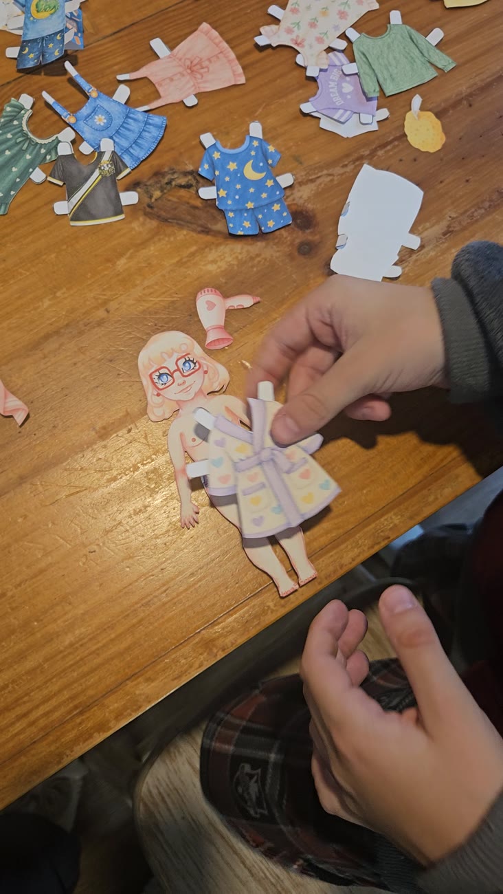 Boneca Bruna recortada, sendo vestida com um roupão