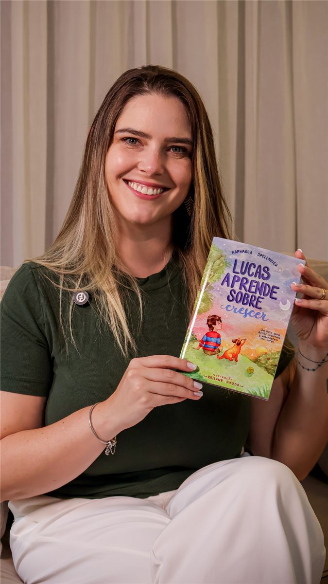 Raphaela Spellmeier segurando o livro Lucas aprende sobre crescer